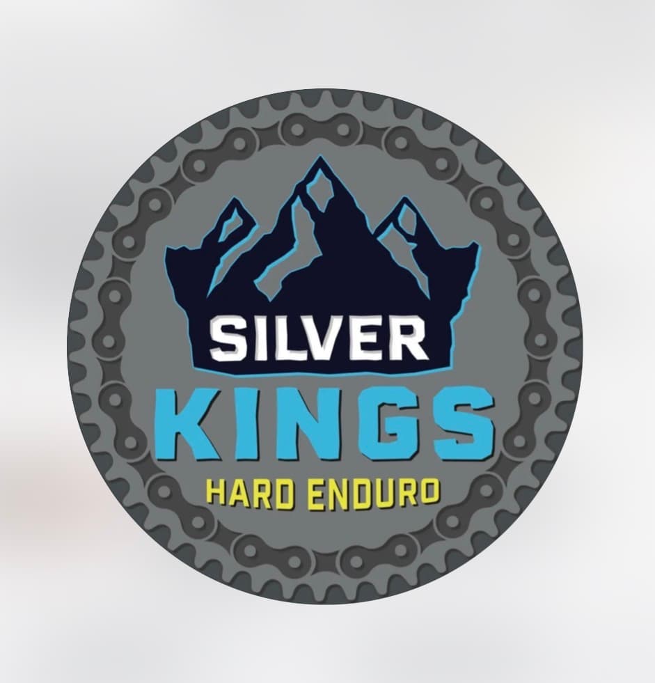 Rundes Silver Kings Hard Enduro Logo mit blauen Bergen und Kette auf grauem Hintergrund.